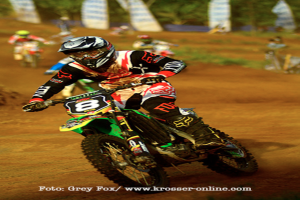 Mehrere Motorradrennfahrer tragen Helme und nehmen an einem Rennen teil, wobei unten auf dem Bild Text angezeigt wird.