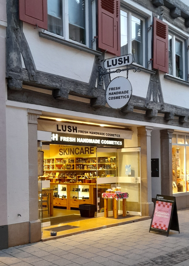 Ein Geschäftsraum mit einem "Lush Skincare"-Schild, der sichtbare Schränke, einen Schreibtisch, einen Stuhl und den Boden zeigt.