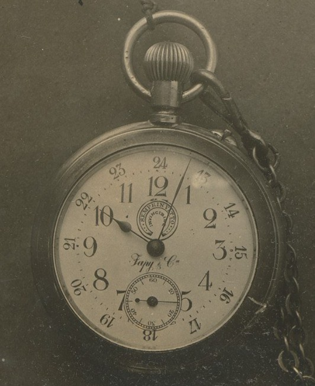 Altes Schwarz-Weiß-Foto einer Taschenuhr mit Kette, mit einer nummerierten Uhr.