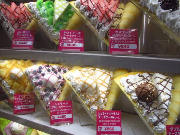 Vitrine voller verschiedener Eissorten, jede mit einem Preisschild, sortiert nach Farbe und Geschmack.