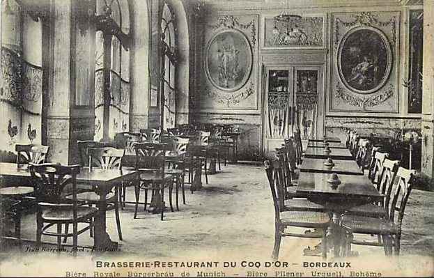 Ein altes Schwarz-Weiß-Foto eines Brasserie-Restaurants im Coq d'or, Bordeaux, Frankreich, voller Tische und Stühle, mit Gemälden an den Wänden, einer Tür in der Mitte und Text unten.