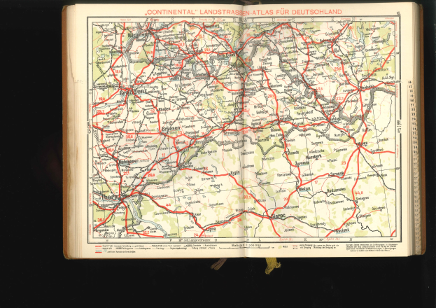 Offenes Buch mit einem detaillierten Straßenkarten-Plan von Deutschland auf einem schwarzen Hintergrund.