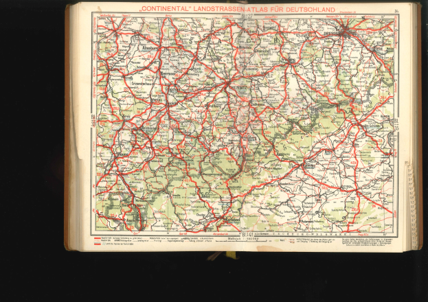 Offenes Buch mit einem detaillierten Kartenausschnitt von Deutschlands Straßen und Autobahnen auf einem schwarzen Hintergrund.