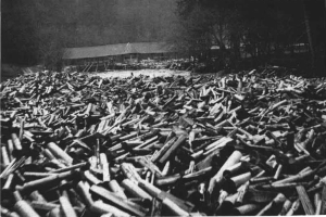 Ein Schwarz-Weiß-Foto eines großen Haufens von Kugeln im Vordergrund, mit einer Hütte und Bäumen im Hintergrund und dem Text "Zweiter Weltkrieg" unten.