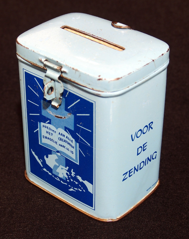 Weißer und blauer Blechspardosen mit einem blauen und weißen Schild, auf dem "Voor de Zending" steht, auf einer schwarzen Oberfläche.